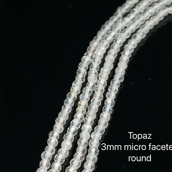 3mm Clear Topaz micro faceted round gemstone strand, on a white background, front overview.