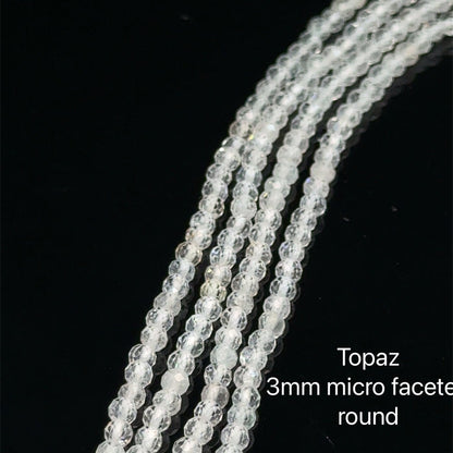 3mm Clear Topaz micro  faceted round gemstone strand, on a white background, front overview.
